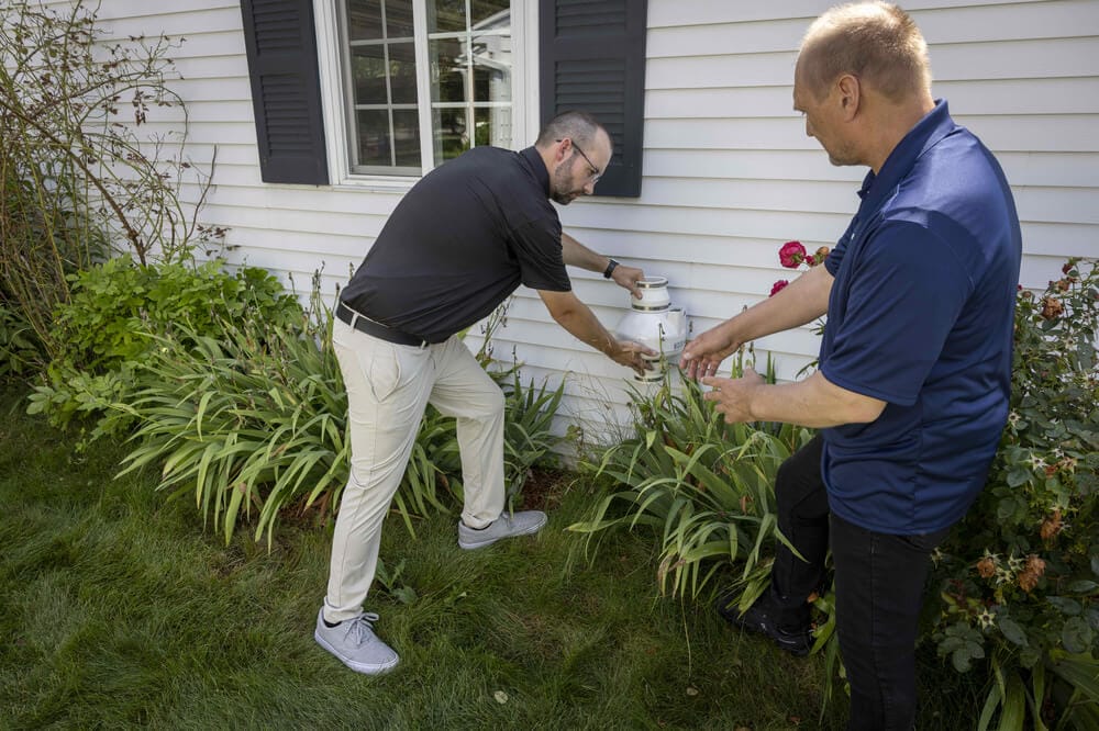 Technicians Inspecting Radon Mitigation System
