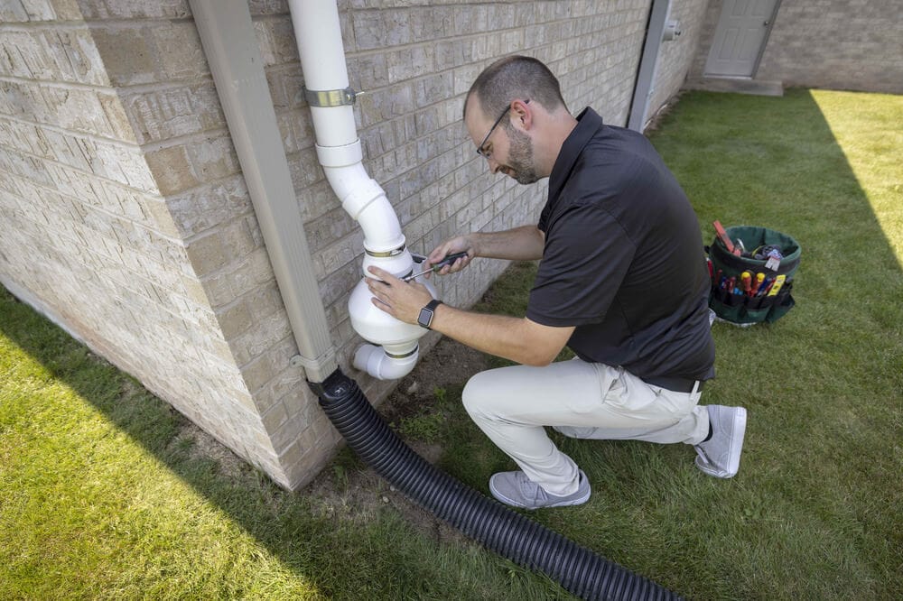 Radon System Repair Technician Working On Completing A Radon Fan Replacement at a Local Home In St. Louis